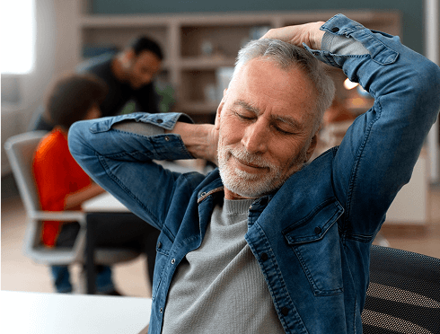 A man with his head in his hands at a desk, indicating stress or contemplation in a work environment.